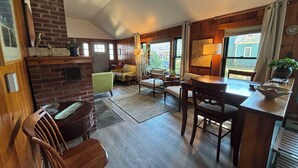 Una sala de estar acogedora con chimenea, comedor y mostrador de cocina.
