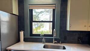 Una cocina con ventana, un lavabo y un lavavajillas.