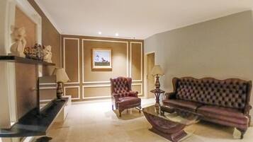 Suíte família, micro-ondas, vista para a cidade | Área de estar