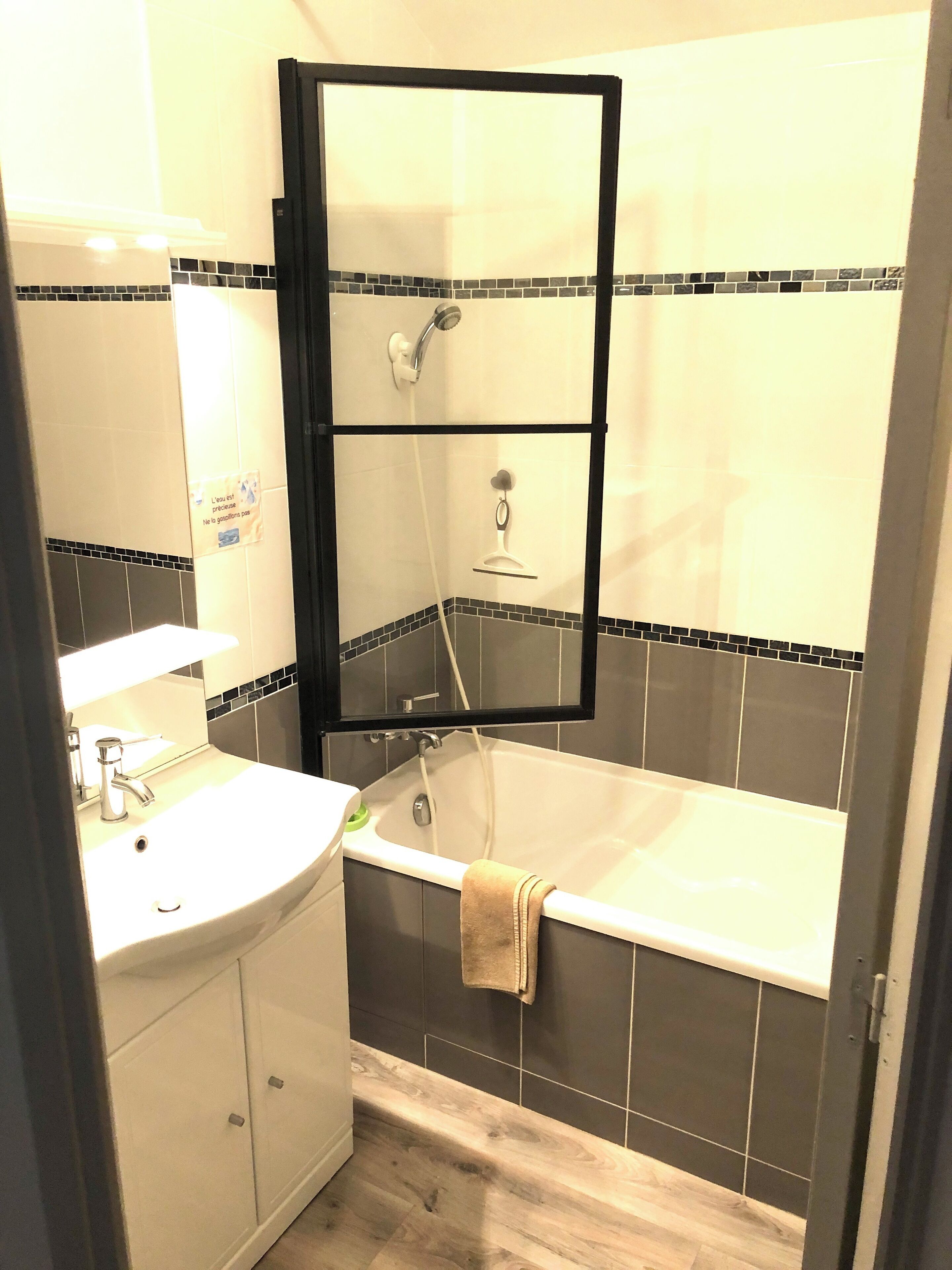 A bathroom with a bathtub, a sink, and a mirror.
