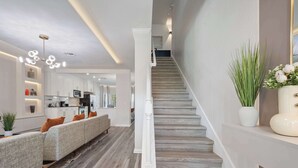 Ein modernes Interieur mit Treppe, einer Sofagarnitur und einer Küchenzeile.
