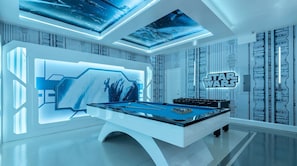 Quarto moderno com mesa de bilhar, decoração Star Wars e design futurista.