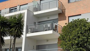 Un edificio moderno de varios pisos con balcones, ventanas amplias y fachada de ladrillo.