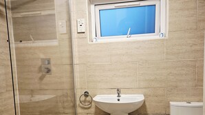 Un baño con ducha, lavamanos e inodoro.
