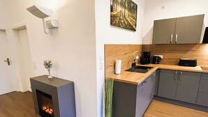 Une cuisine moderne équipée d’un poêle à bois, d’un évier et d’une machine à café.