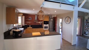 Une cuisine moderne avec des meubles en bois, un îlot central et un luminaire suspendu.