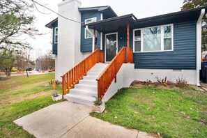 A two-story house with a front porch and a staircase.