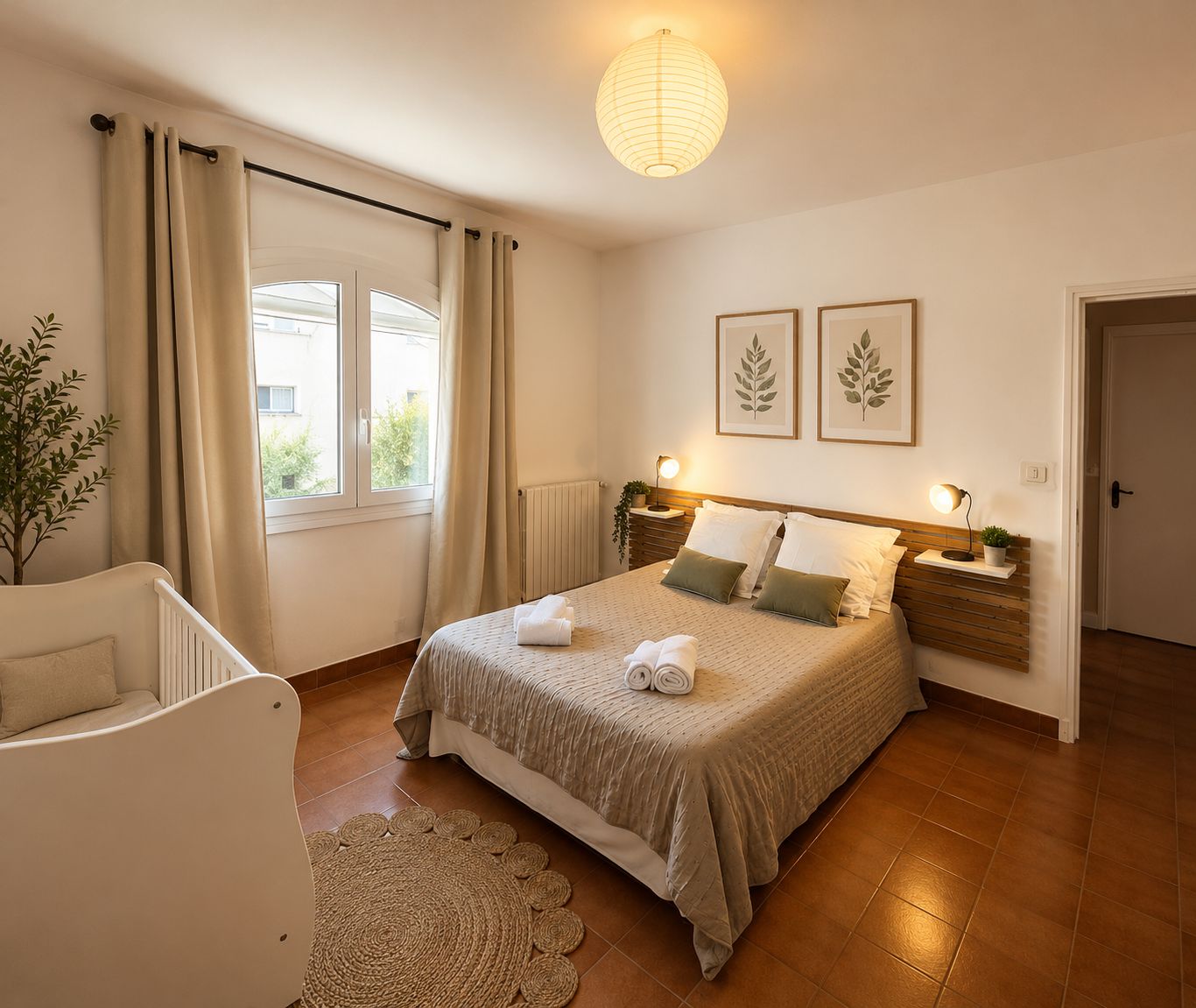 A bedroom with a bed, bedside lamps, a window with curtains, a plant, and framed artwork on the wall.