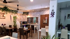 A modern restaurant with a marble backsplash, wooden accents, and potted plants. - Shams Thoddoo (Thoddoo)