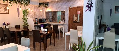 A modern restaurant with a marble backsplash, wooden accents, and potted plants.