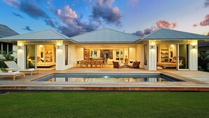 Una casa moderna con piscina, ventanas amplias y un interior bien iluminado.