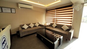 A modern living room with a sectional sofa, a glass coffee table, and a built-in entertainment unit. - Staykart Z (Bhilwara)
