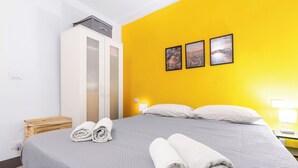 Ein Hotelzimmer mit einem Bett, einem Kleiderschrank und drei gerahmten Bildern an der Wand.