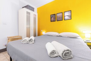 Una camera d'albergo con un letto, un armadio e tre quadri appesi al muro.