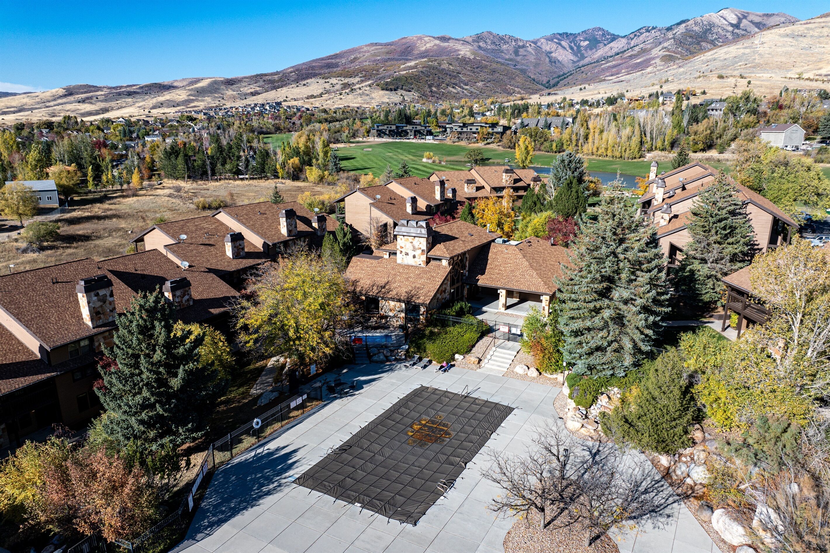 A residential area with houses, a large open square, and mountains in the background.