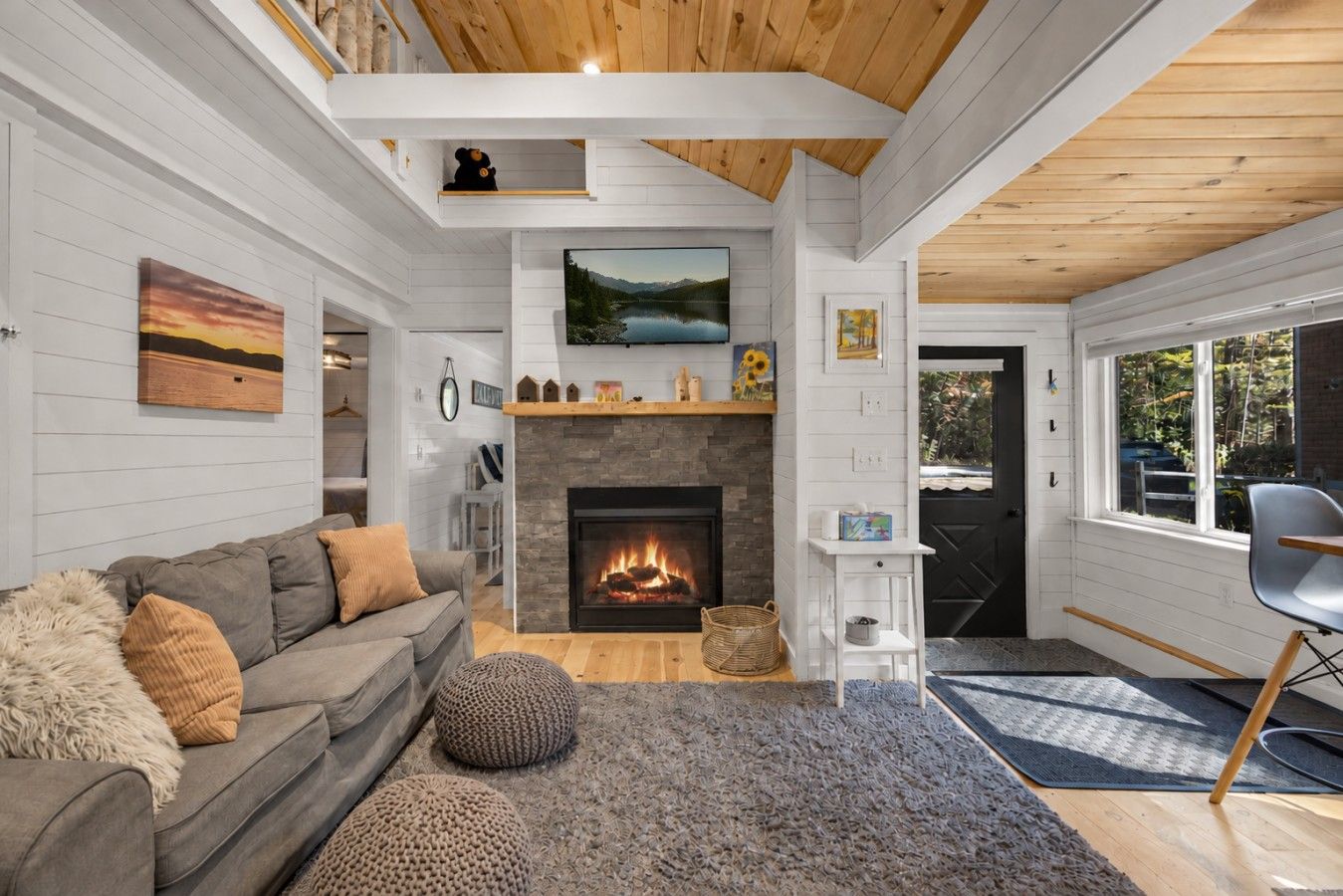 A cozy living room with a fireplace, a sofa, and a television.