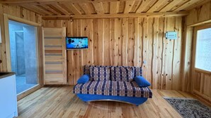 A cozy room with wooden walls and a curved sofa.