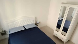Une chambre à coucher avec un lit, une armoire et une table de chevet.