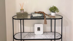 Un téléviseur à écran plat fixé au mur, au-dessus d’une table ronde dont le plateau est en marbre.