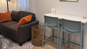 Un salon moderne avec un canapé, une petite table et un appareil de climatisation.