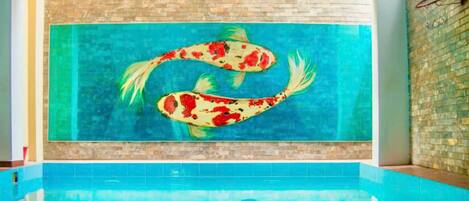 A swimming pool with a mural of koi fish.