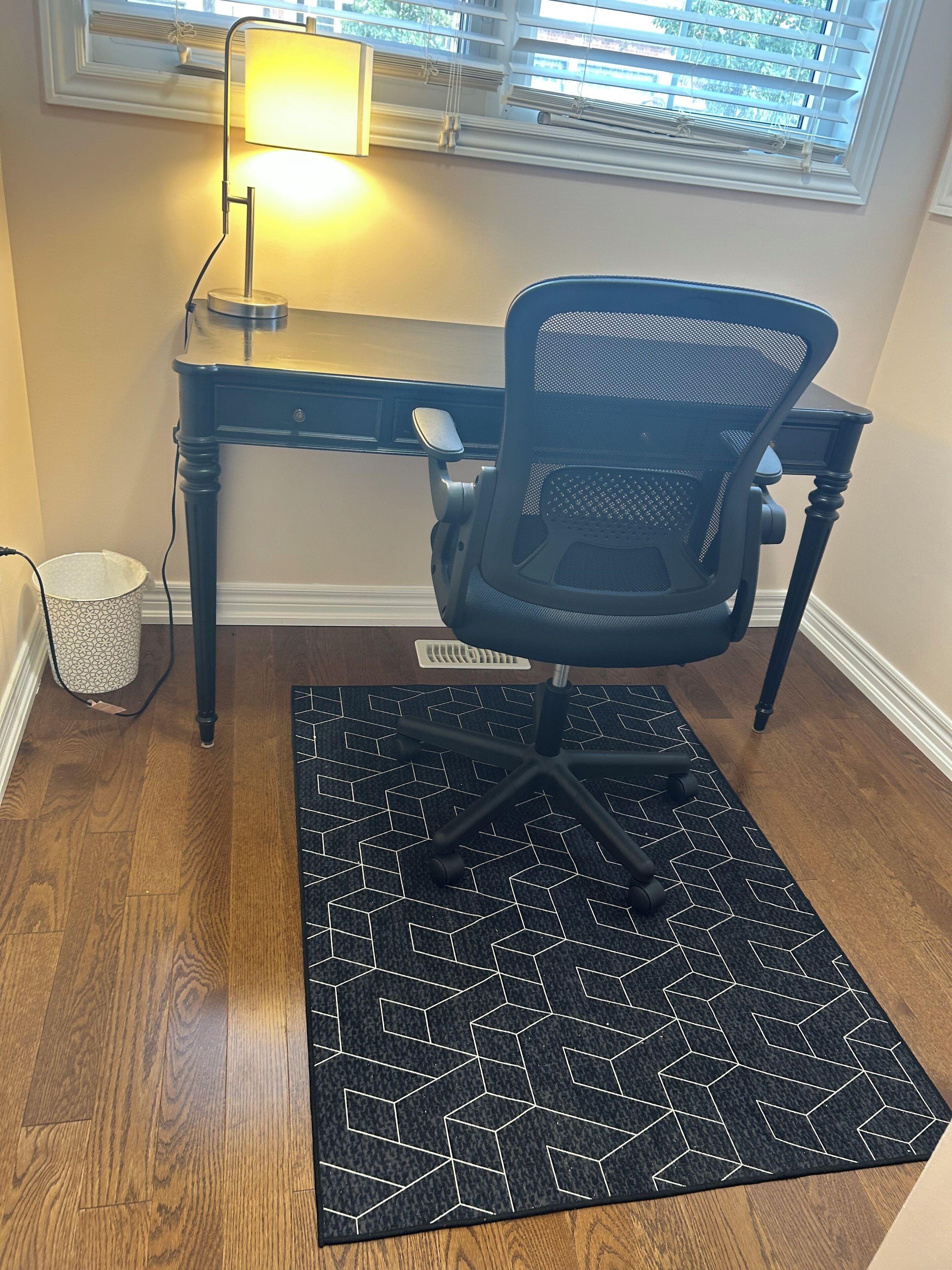 Un espace de travail comprenant un bureau, une chaise et une lampe.