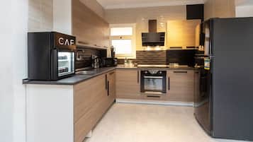 Cozinha moderna com forno embutido, micro-ondas e máquina de café.