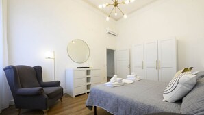 A bedroom with a bed, a chair, a wardrobe, and a mirror. - Hidden Gem with Private Garden (Firenze)