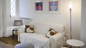 A cozy living room with a sofa, a lamp, and two small tables. - Hidden Gem with Private Garden (Firenze)