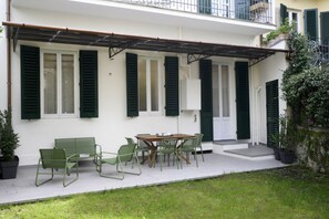 A patio with a table and chairs, a bench, and a potted plant.