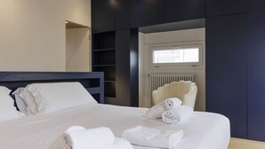 Ein modernes Hotelzimmer mit einem großen Bett, einem Einbauschrank, einem Fenster mit Jalousien und einer Heizung.
