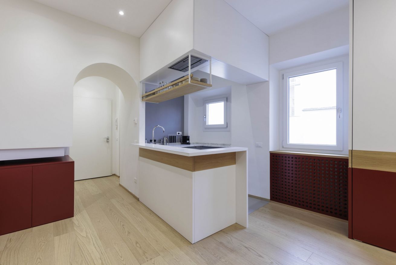 A modern kitchen with a central island, built-in appliances, and a window providing natural light.