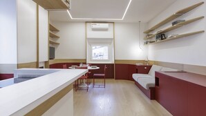Eine moderne Küche mit einer zentralen Kochinsel, einem Essbereich mit Tisch und Stühlen sowie Einbauschränken an den Wänden.