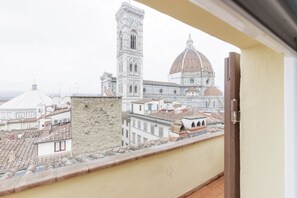 A balcony with a view of historic buildings, including a tower and a dome. - Duomo View Apartment (Firenze)
