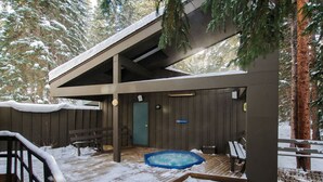 Un espacio al aire libre techado con un jacuzzi, terraza de madera y una puerta que indica "Dine Terrace".