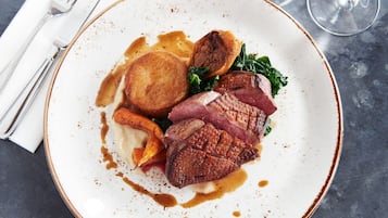 A plate of food with steak, roasted potatoes, and greens.