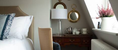 A bedroom with a bed, a chair, a dresser, a mirror, a lamp, and a radiator.