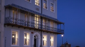 Un edificio de dos pisos con un balcón en el piso superior, un letrero que dice "Albright House", y una pequeña estructura en forma de cúpula en el techo.