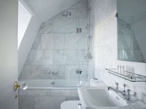 Un baño moderno con ducha de vidrio, bañera independiente y tocador con espejo.