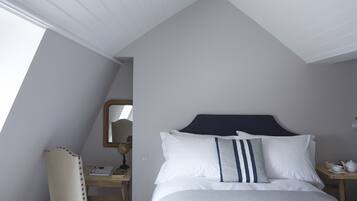 A bedroom with a bed, a desk, a chair, and a nightstand.