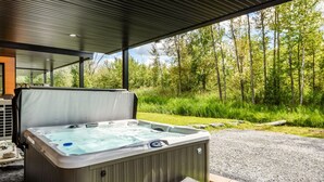 Un bain à remous extérieur avec vue sur une forêt.