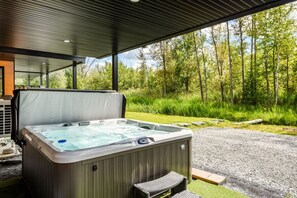 A hot tub outdoors with a view of a forest.