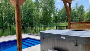 Un bain à remous avec des marches et une piscine dans un jardin.