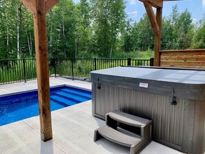 A hot tub with steps and a pool in a backyard.