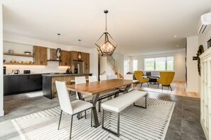 A modern kitchen with a central island, wooden cabinets, and pendant lighting.