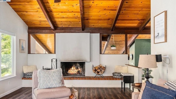 Una sala de estar acogedora con chimenea, vigas de madera, un sofá y una mesita de centro.