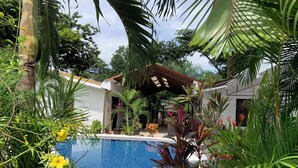 A private pool surrounded by lush greenery and a covered patio area. - Beautiful complex with swimming pool, close to the beach and downtown. (Sámara)