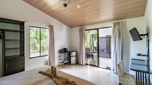A hotel room with a bed, a desk with a computer, a ceiling fan, a sliding glass door to the outside, and a small kitchenette. - Beautiful complex with swimming pool, close to the beach and downtown. (Sámara)