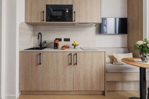 A modern kitchen with a microwave, sink, and a flat-screen TV. - Elegant Apartment - 1br- 4P- Trocadero (Paris)
