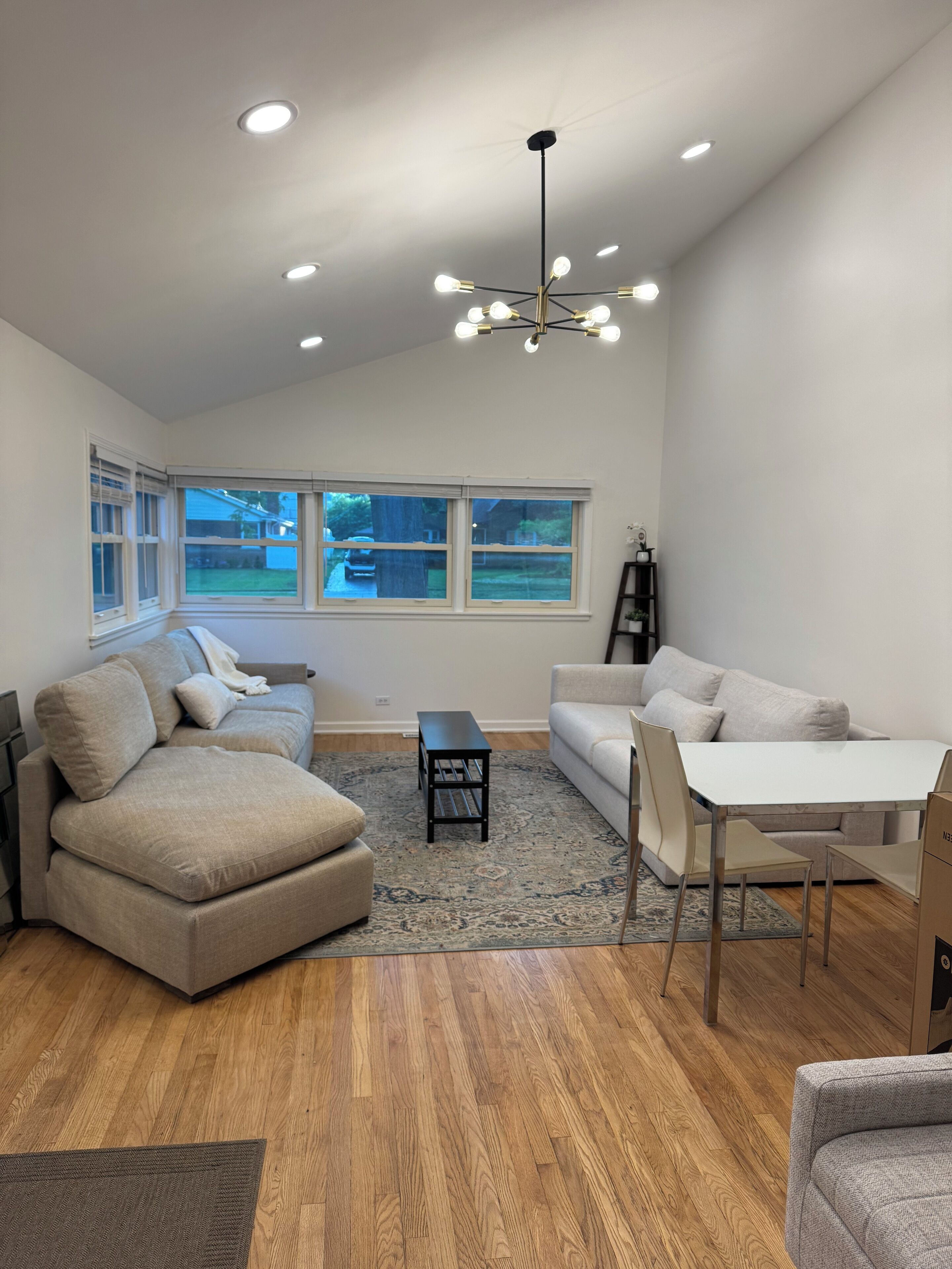 Una sala de estar moderna con un sofá modular, una mesita y una mesa de comedor con sillas.